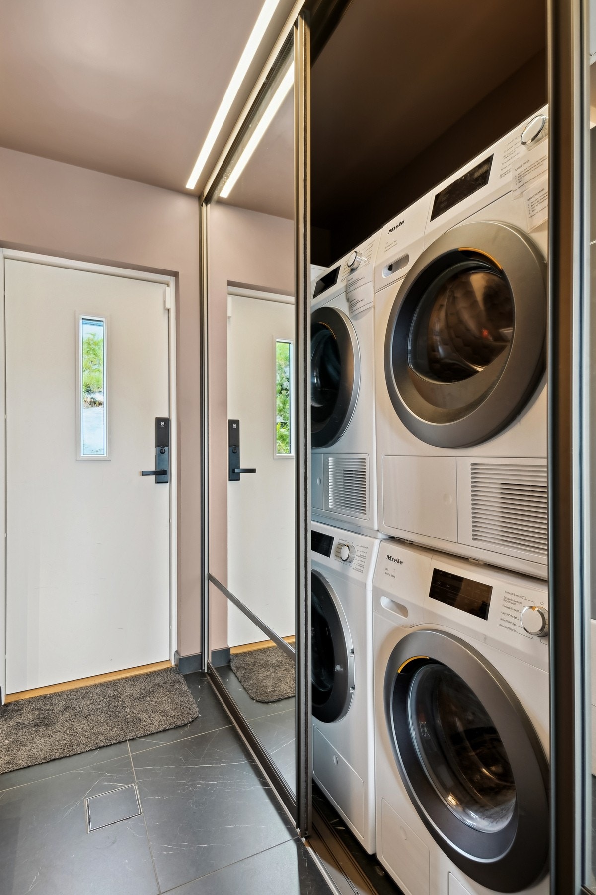 Skjult bak skyvedørene har vaskerommet et hendig hyllesystem og dobbelt opplegg for vaskemaskin. Galleribilde