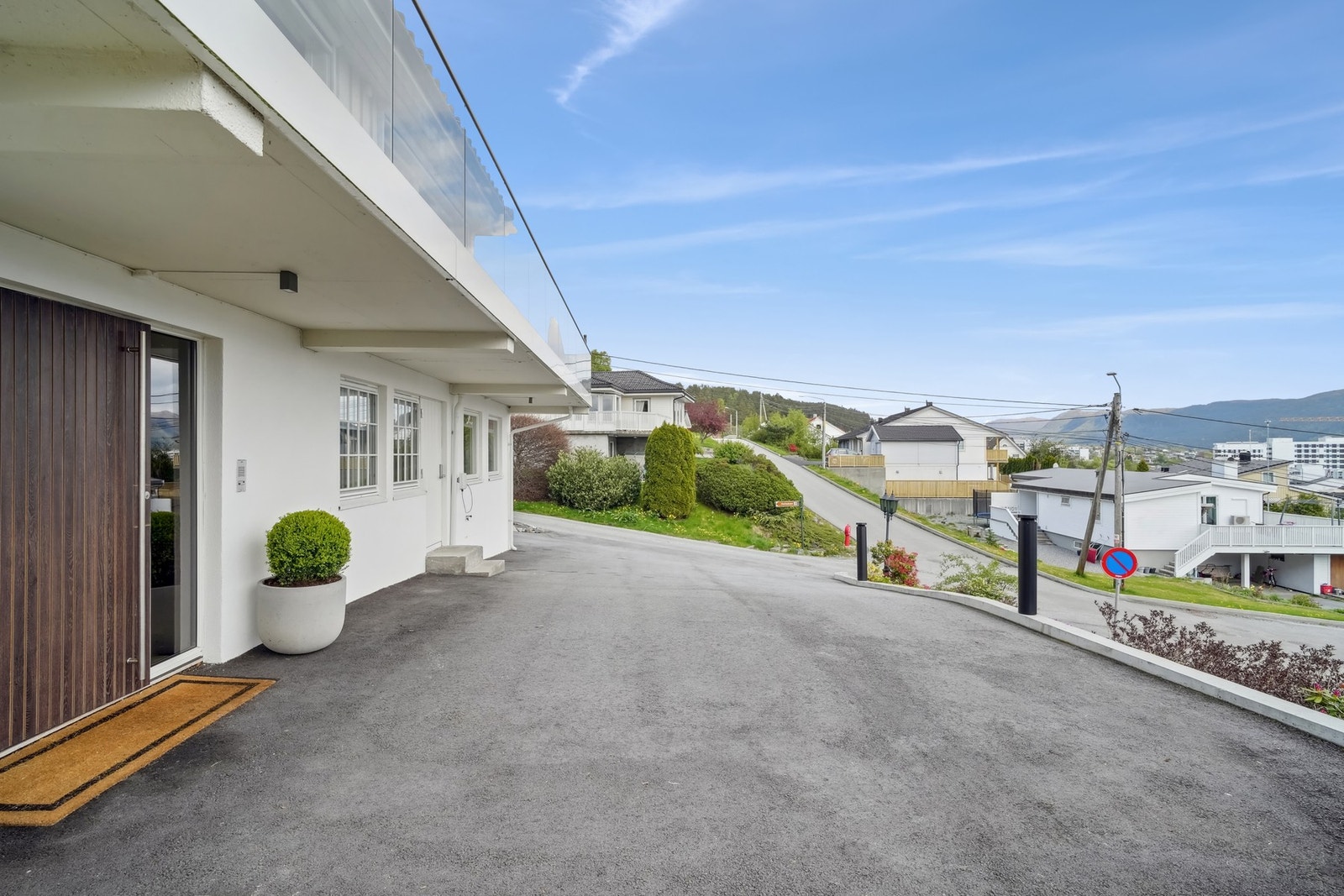 Hovedinngangen er overbygd og trappefri, og har en massiv ytterdør med dørpumpe og ekstra store håndtak. Galleribilde