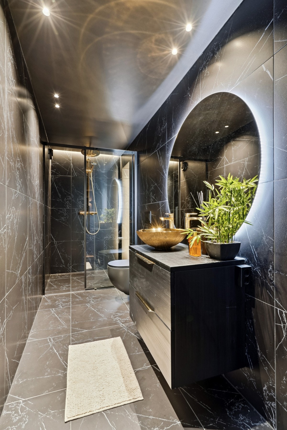 Badet har gulvvarme og ekstra store fliser, og er gjennomført i mørk marmorutførelse for en herlig spa-følelse hjemme. Galleribilde