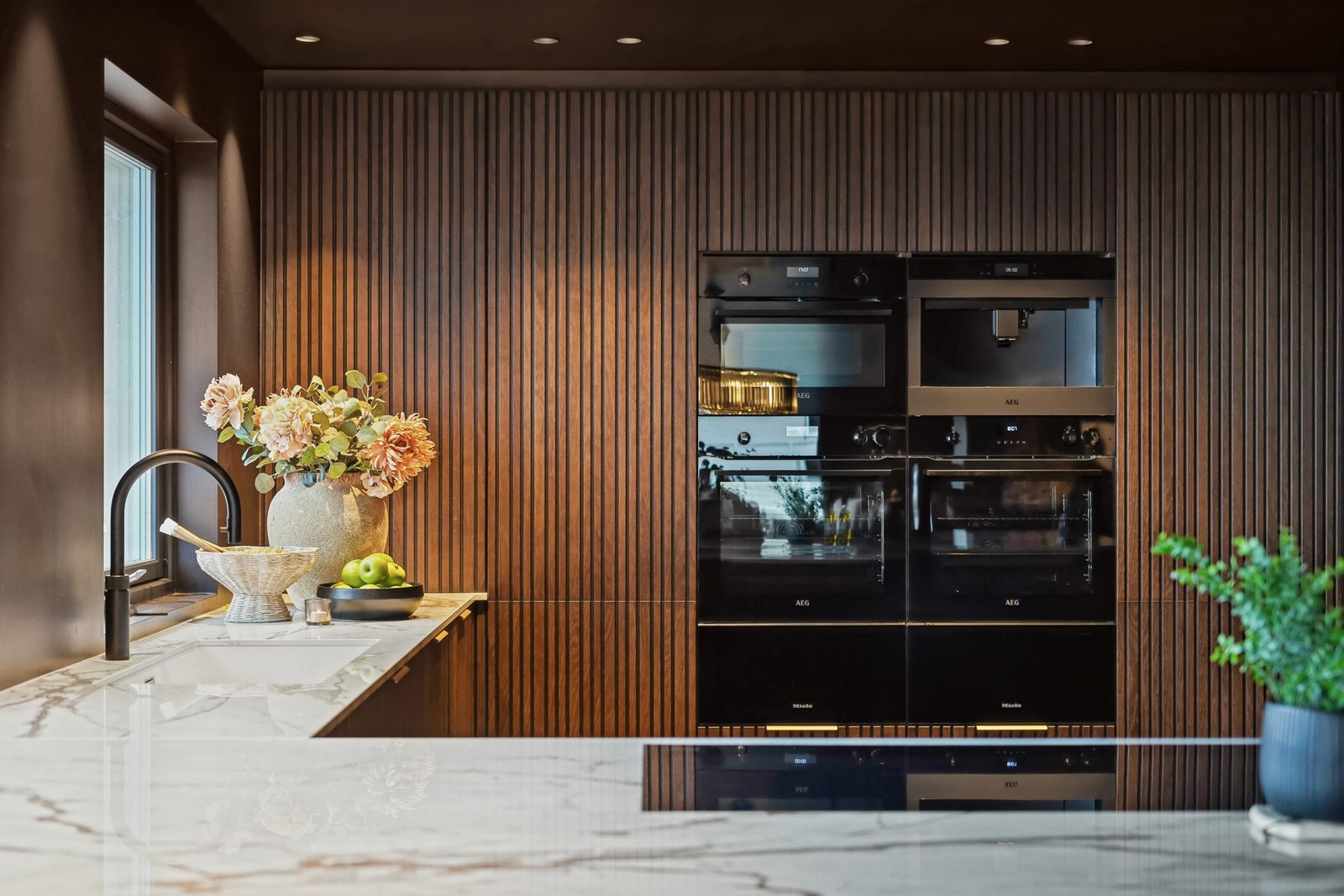 Et moderne sett med hvitevarer er holdt i sort; integrerte fra kvaliteslevrandørene AEG og Miele. Galleribilde