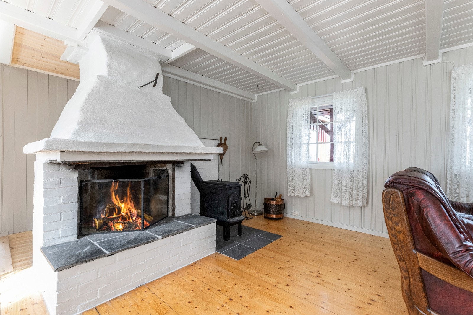 Peis og vedovn ved siden av som bidrar til god varme og hyggelig stemning Galleribilde