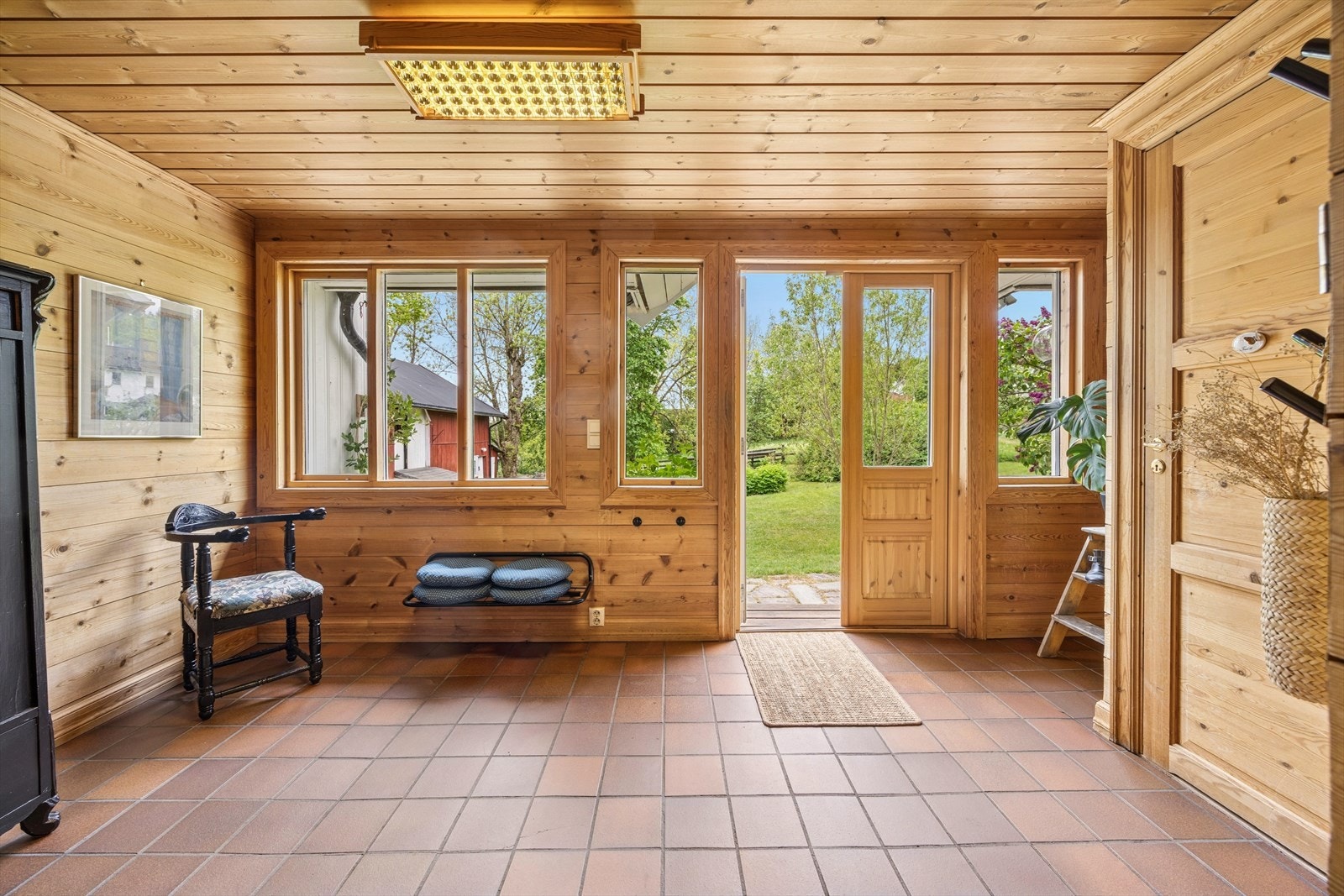 Romslig og praktisk entré med flislagt gulv og gode vindusflater Galleribilde