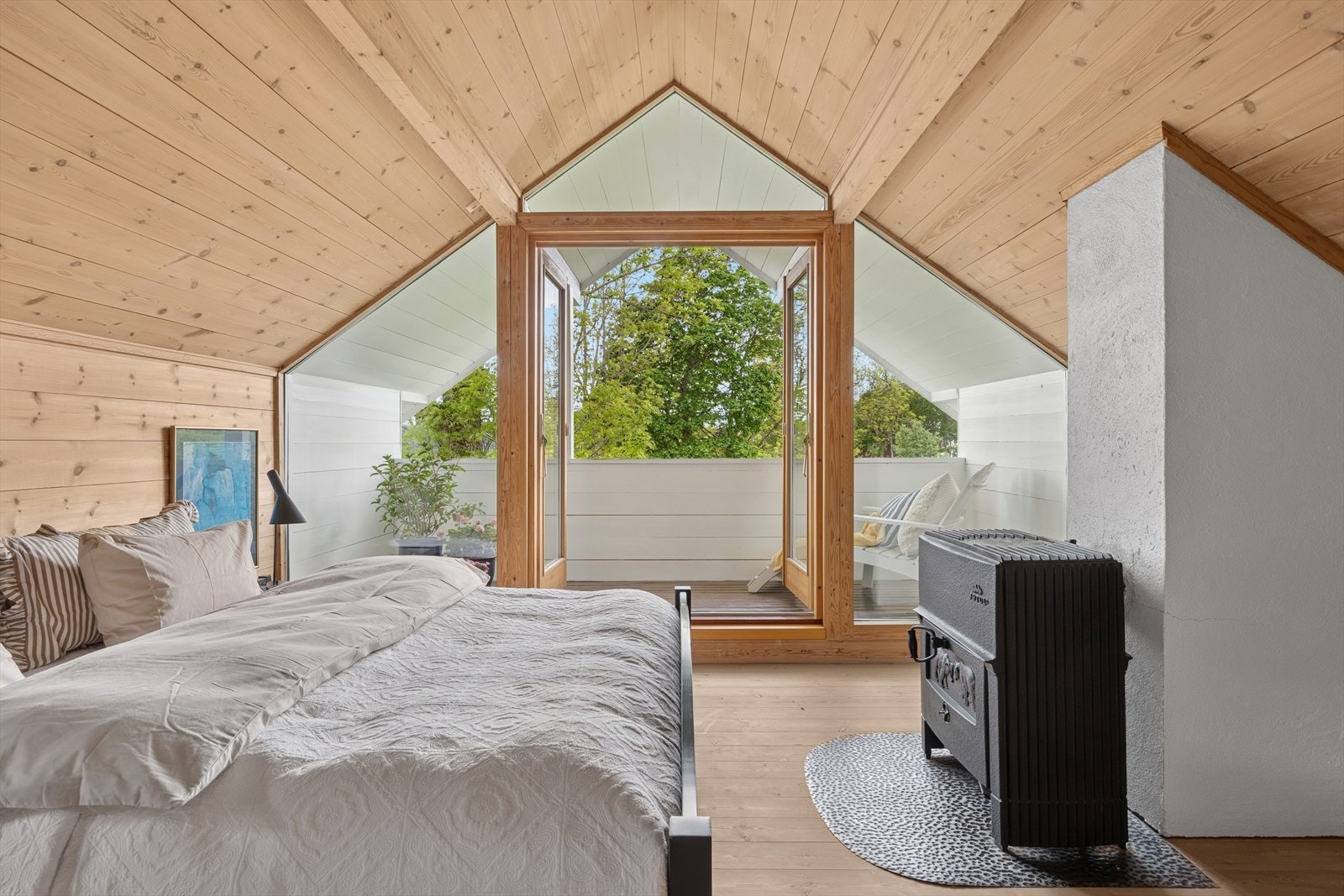 Den ene veggen på hovedsoverommet er fullt dekket av vinduer og gir flott utsikt mot hagen og låven. Galleribilde