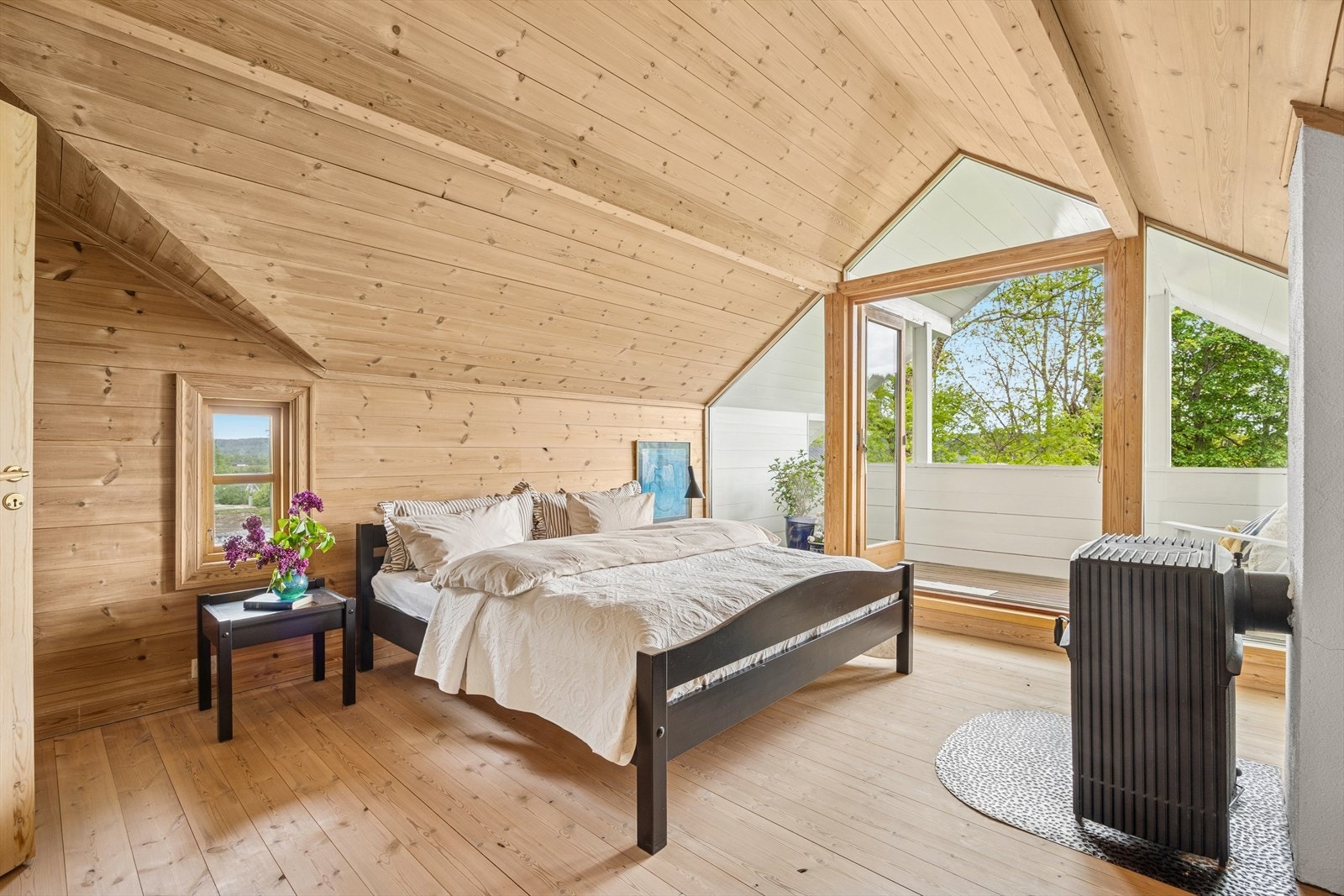 Lyst og luftig rom med synlige bjelker og vedovn. Galleribilde