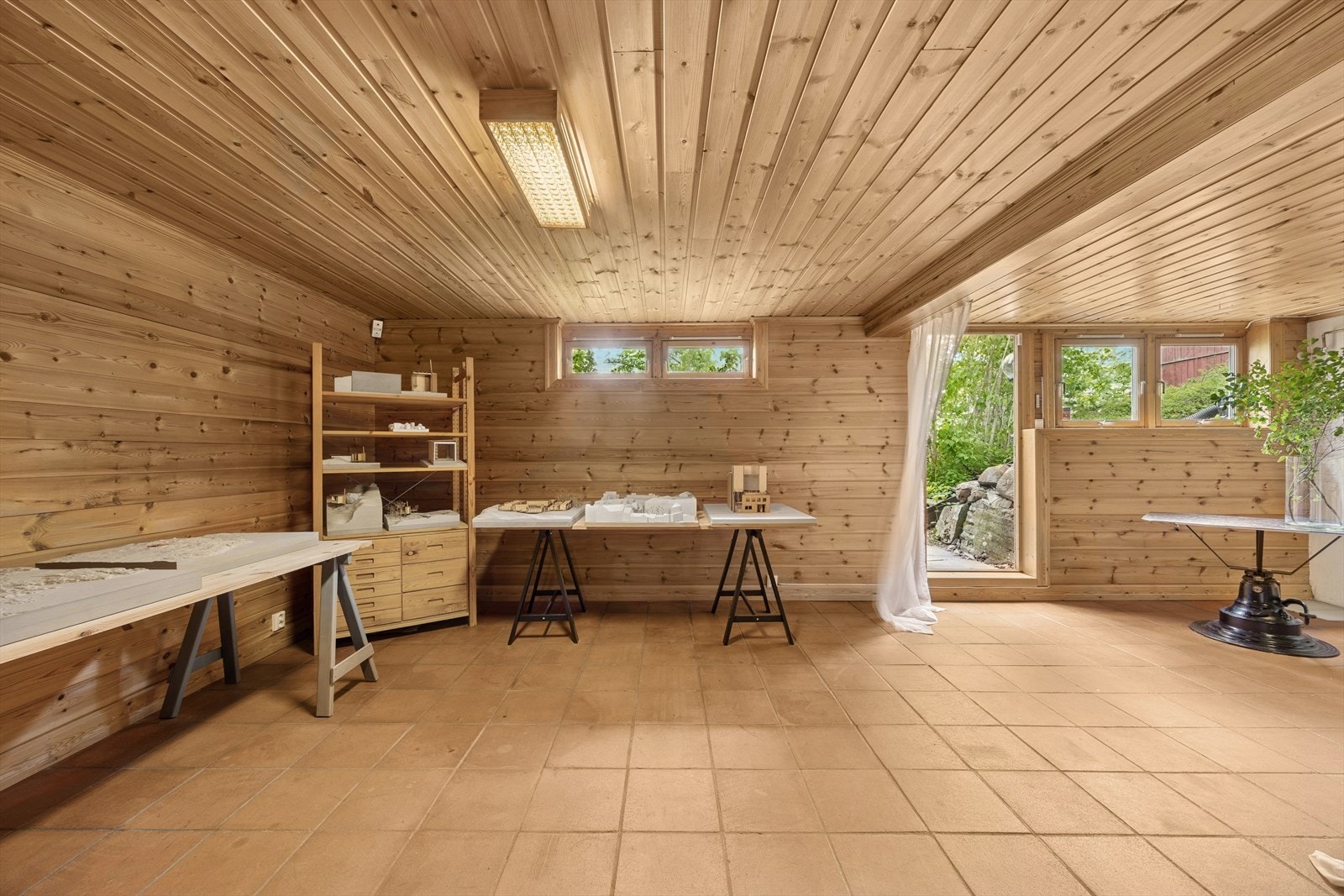 Et stort rom som i dag fungerer som både oppholdsrom og vaskesone, delt naturlig av vinkelen i rommet. Galleribilde