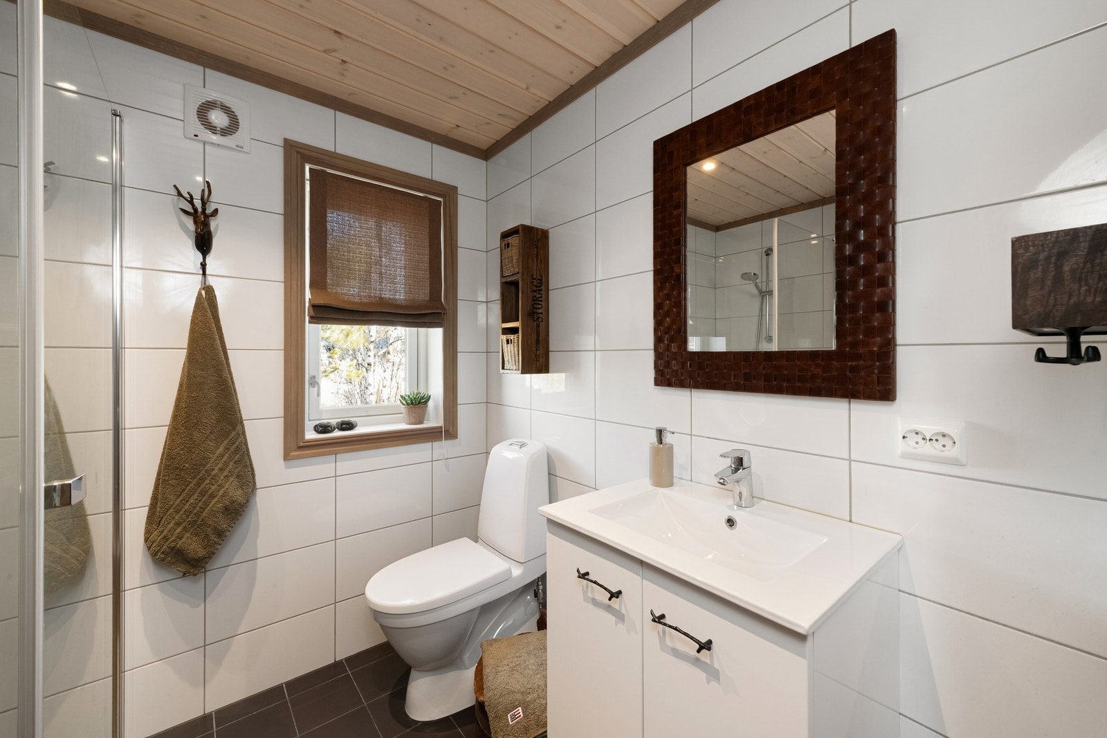 Badet er innredet med toalett, servant med innredning og dusj. Galleribilde