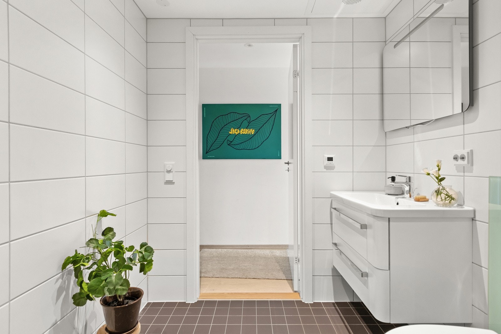 Rommet har opplegg for vaskemaskin, og under servanten finnes et praktisk benkeskap med glatte fronter. Galleribilde