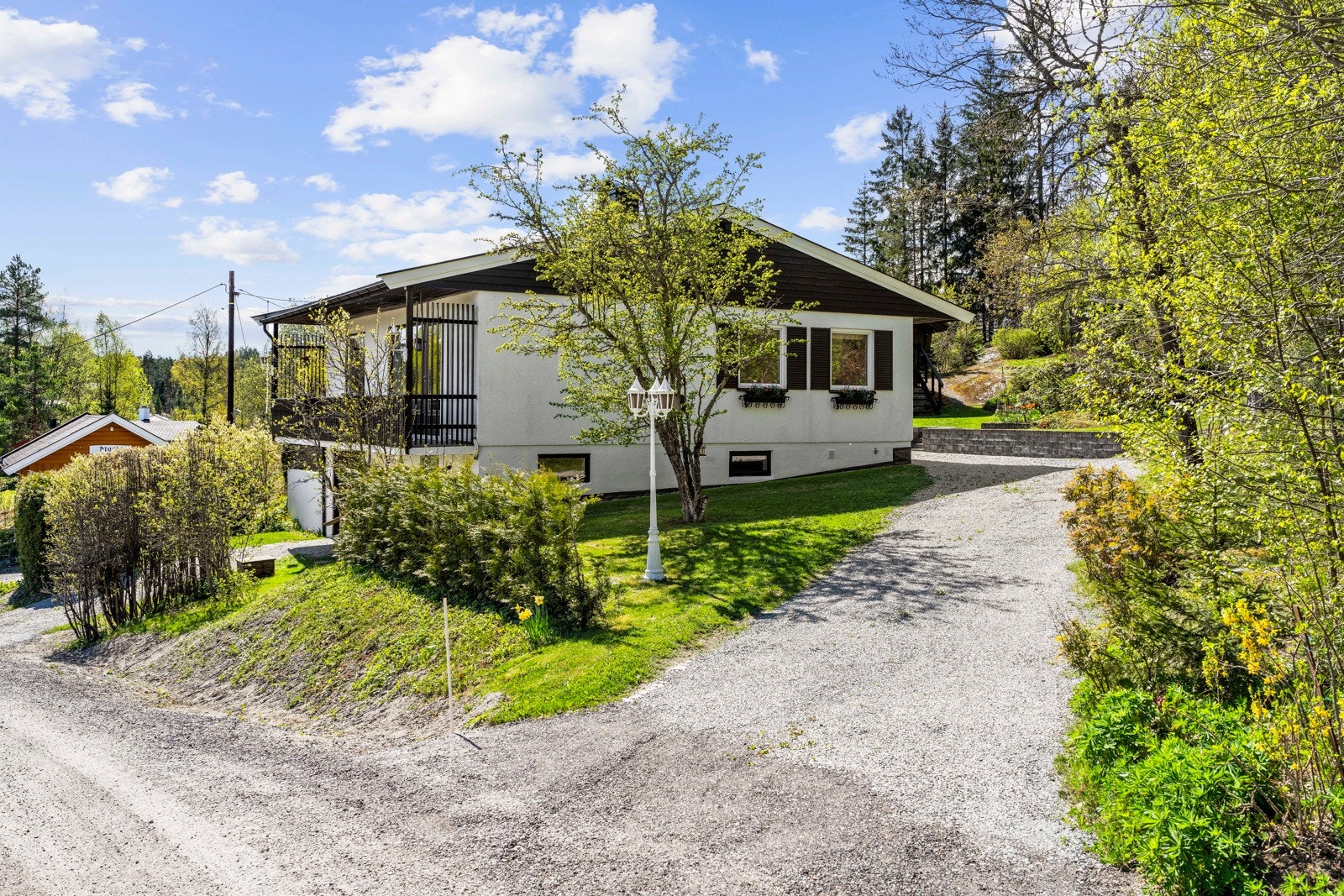 en sjarmerende enebolig over to etasjer, idyllisk plassert ved markagrensen, omgitt av en vakker og velstelt hage. Galleribilde