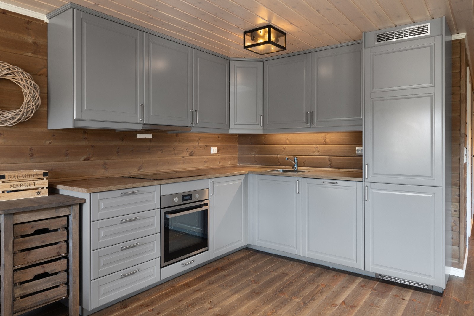 Kjøkkenet er trukket inn i rommet i en klassisk vinkel med overskap montert oppunder taket for maksimal utnyttelse. Galleribilde