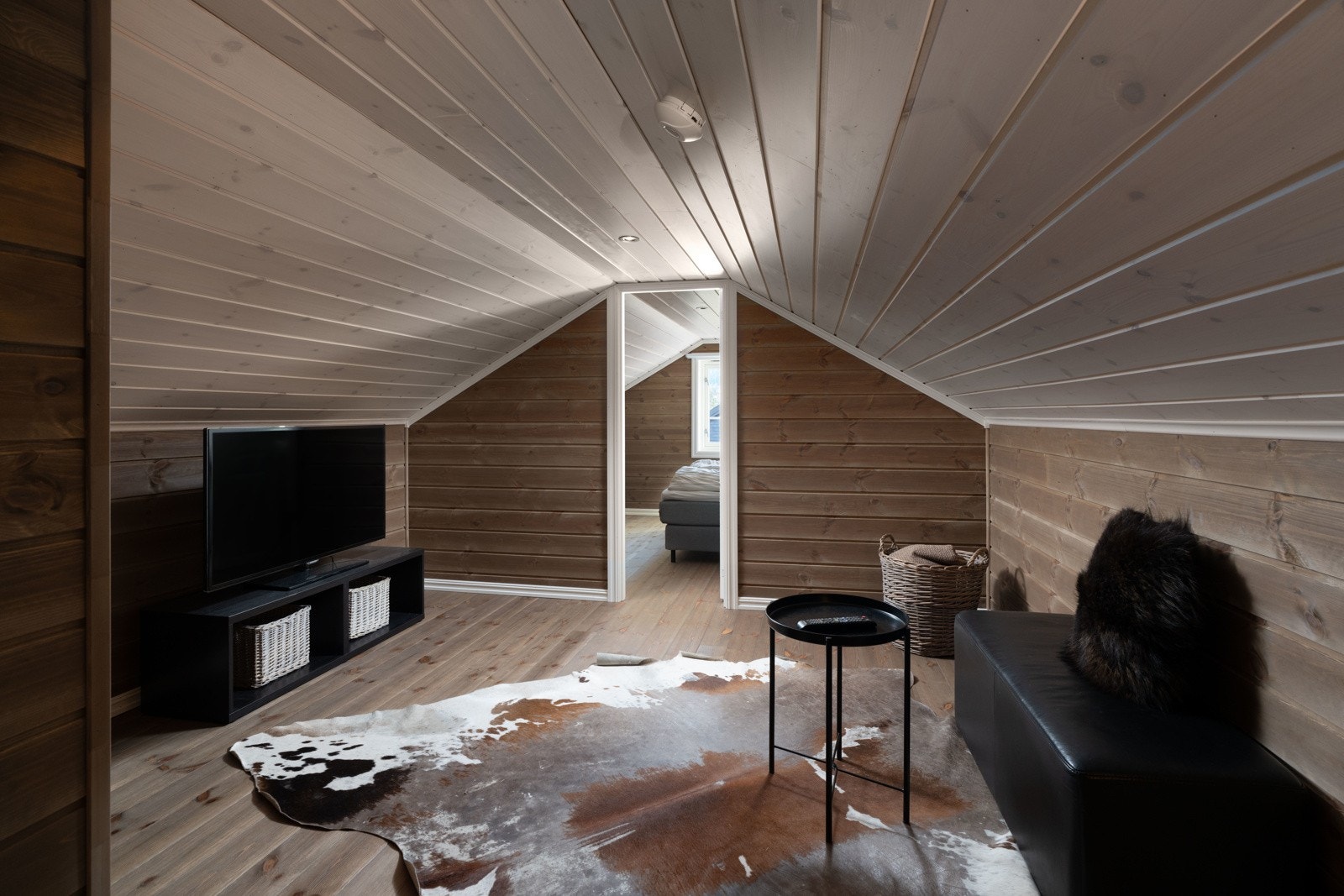 Her kan barna kose seg oppe med tv og gaming, mens de voksne kan prate nede. Stuen har mønet himling med downlights, panel på veggene og furugulv. Galleribilde