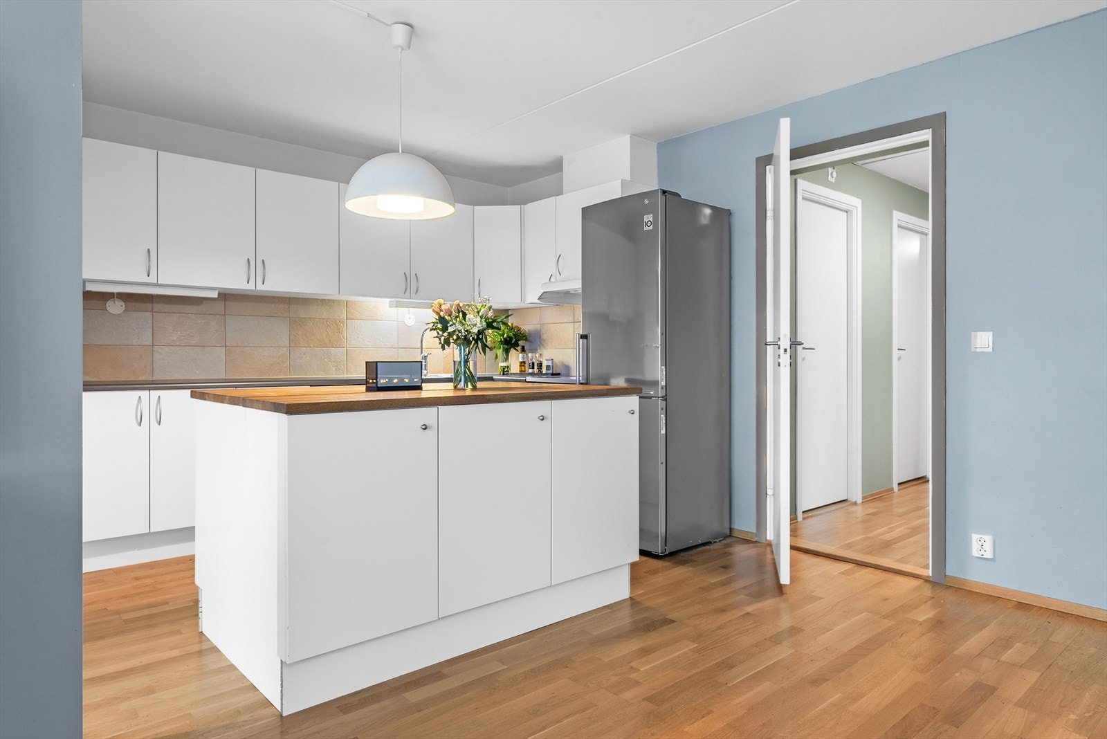 Aubo kjøkkeninnredning med glatte fronter, laminat benkeplate med nedfelt vask-og skyllekum. Hvitevarer som oppvaskmaskin, komfyr og kjøl/frys medfølger salget. Galleribilde