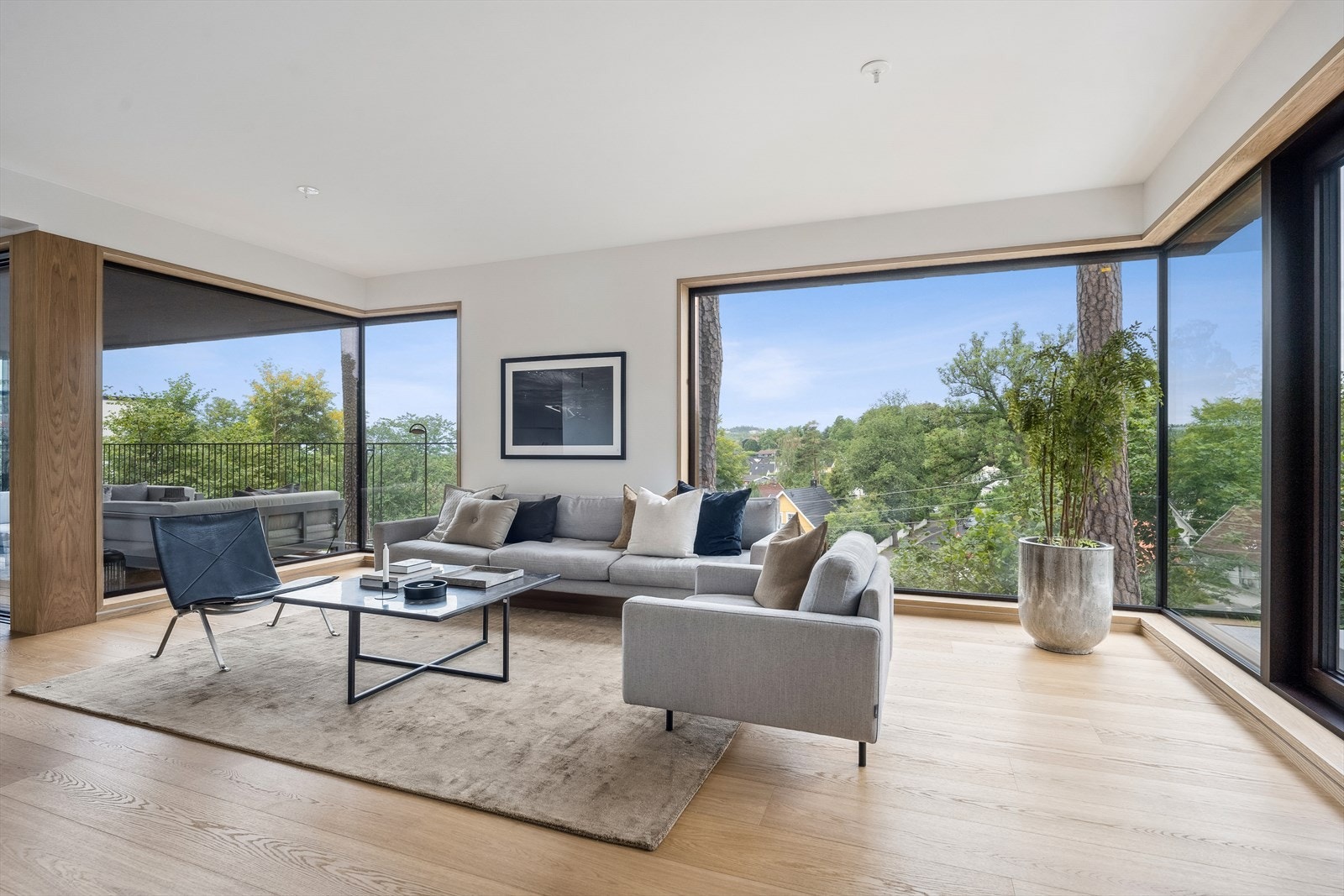 Stue med gode møbleringsmuligheter og anledningen til å nyte siktlinjene med vindusflater fra gulv til tak Galleribilde