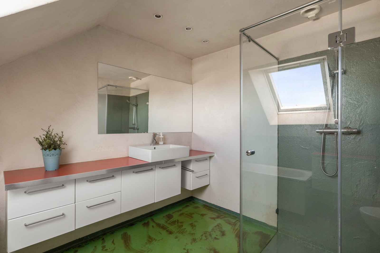 Badet er av god størrelse og er innredet med seksjon/ benk med vask, badekar, toalett på gulv og dusjnisje med glassvegger. Galleribilde