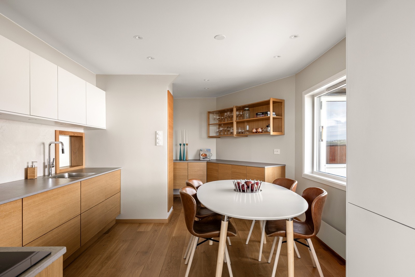 Det er et lekkert og tidløst kjøkken med slette fronter i en flott og behagelig fargepalett. Masse skap- og benkeplass og man har også plass til et stort frokostbord. Galleribilde