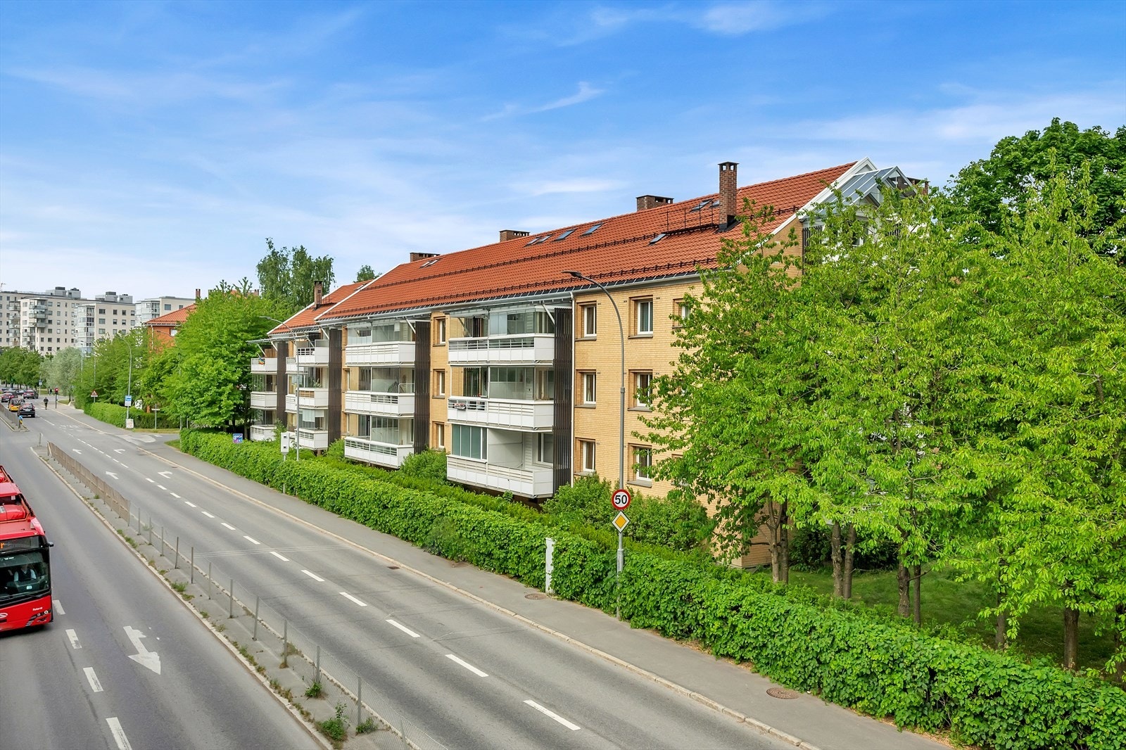 Fasade. Både garasjer og parkeringsplasser kan leies gjennom borettslaget. Flere av parkeringsplassene er ladeplasser (bil). Galleribilde