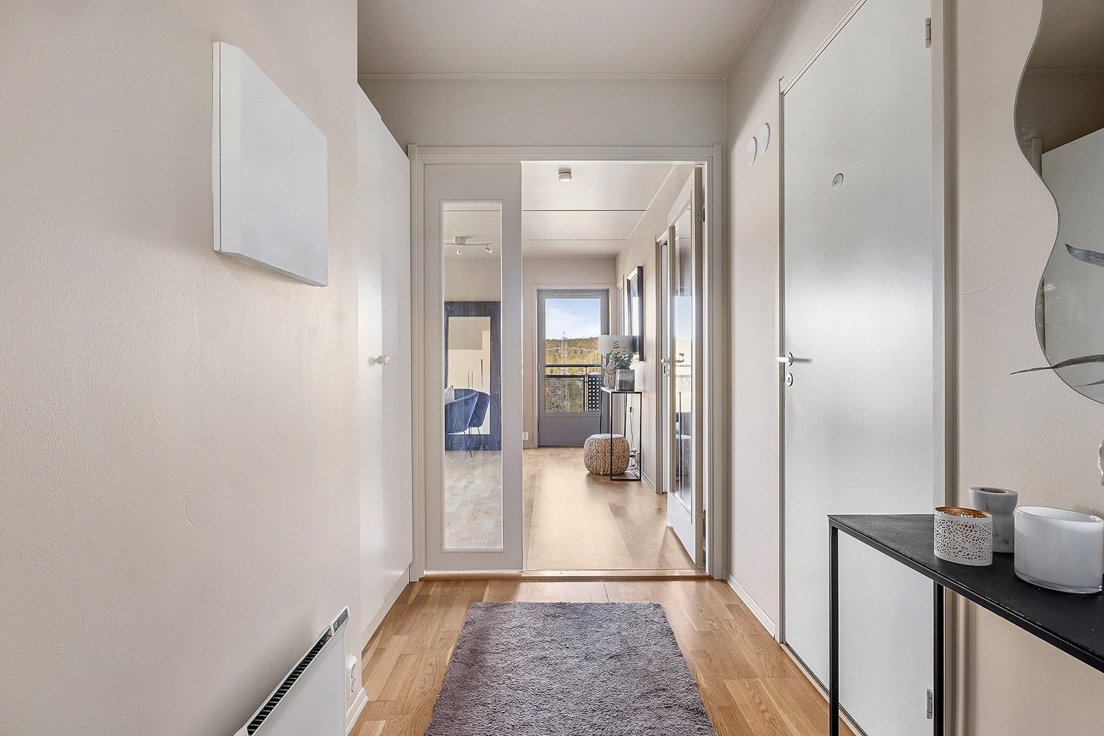 Entréen gir et godt førsteinntrykk som blir med gjennom resten av leiligheten. Fargetonene er lyse, moderne, og behagelige farger. Her får du plass til å henge fra deg yttertøy og sette skoene på plass. Galleribilde