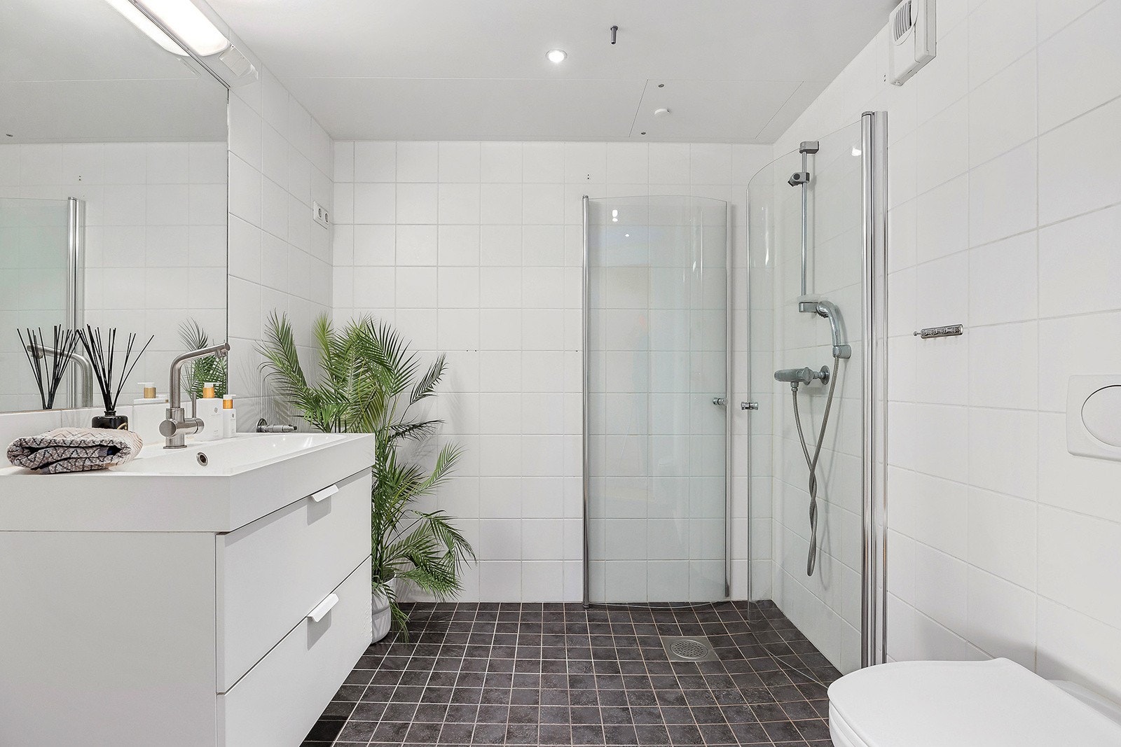 Stort flislagt bad med gulvvarme og downlights i tak. Galleribilde