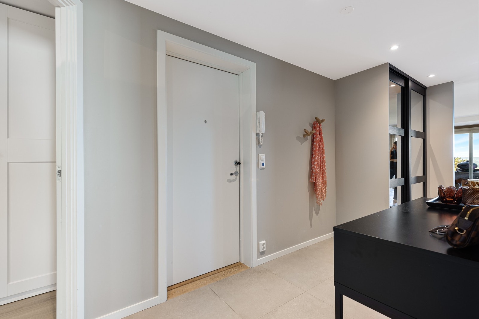 Entré med skyvedørsgarderobe, entrédør med porttelefon og adkomst til leilighetens to soverom Galleribilde