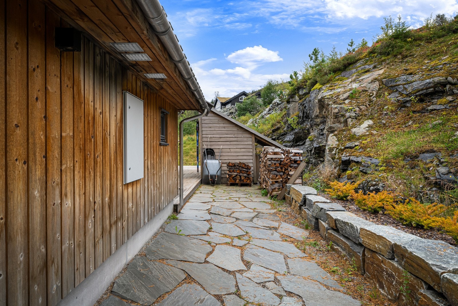 Skiferplatting på baksiden av hytten. Utvendig bod og innvendig sportsbod. Galleribilde