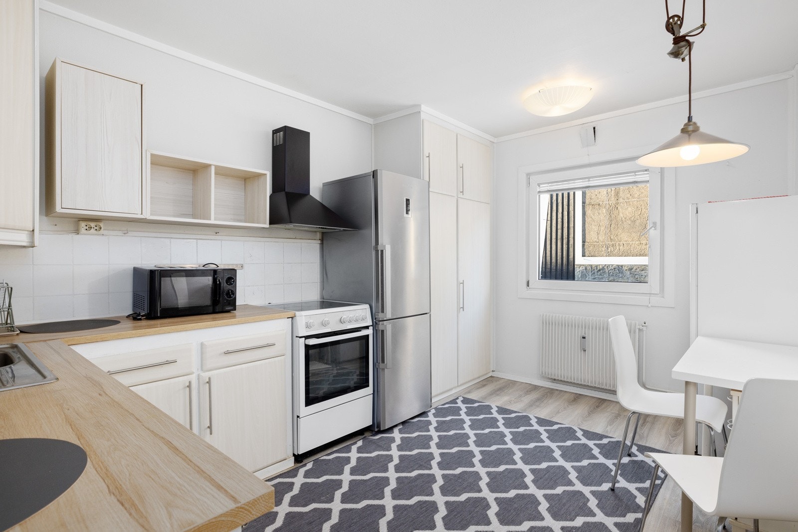 Lyst og romslig kjøkken med nyere laminat på gulv og malte vegger. Galleribilde