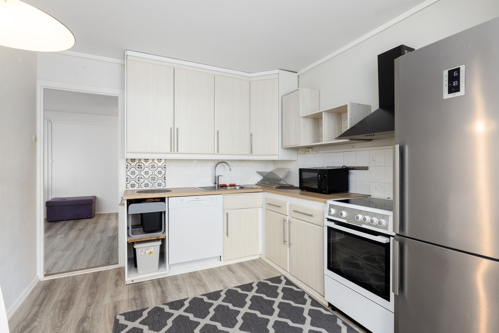 Kjøkkeninnredningen har lyse glatte fronter og benkeplate av laminat. Det er plass til frittstående kjøl-/fryseskap, oppvaskmaskin og komfyr. Galleribilde