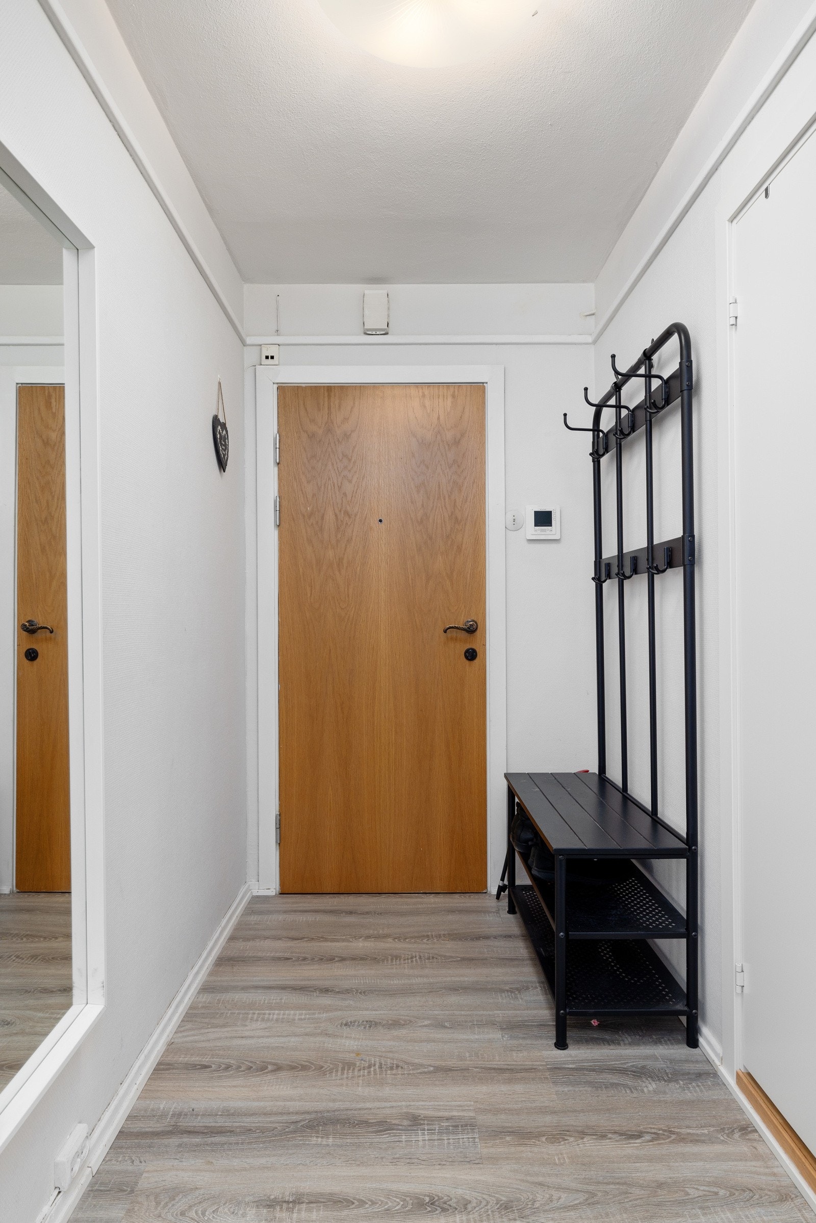 Lys entré med plass for oppheng av yttertøy, og enkel øvrig møblering. Galleribilde