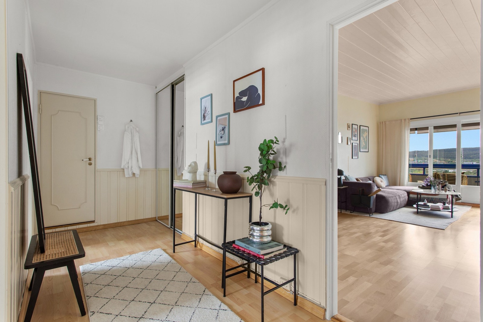 Velkommen inn en lys og romslig entré med praktisk skyvedørsgarderobe med speil. Galleribilde