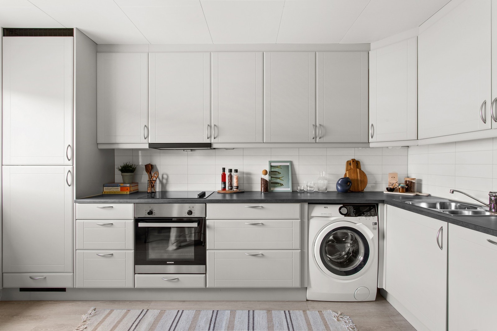 Innredningen har lyse profilerte fronter og laminat benkeplate, og kjøkkenet er utstyrt med hvitevarer som kjøl/frys, komfyr, platetopp, oppvaskmaskin og vaskemaskin. Galleribilde