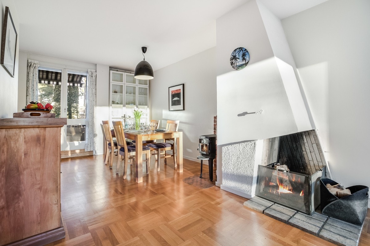 Åpen peis og peisovn sørger for en lun romopplevelse og skaper en hyggelig atmosfære Galleribilde