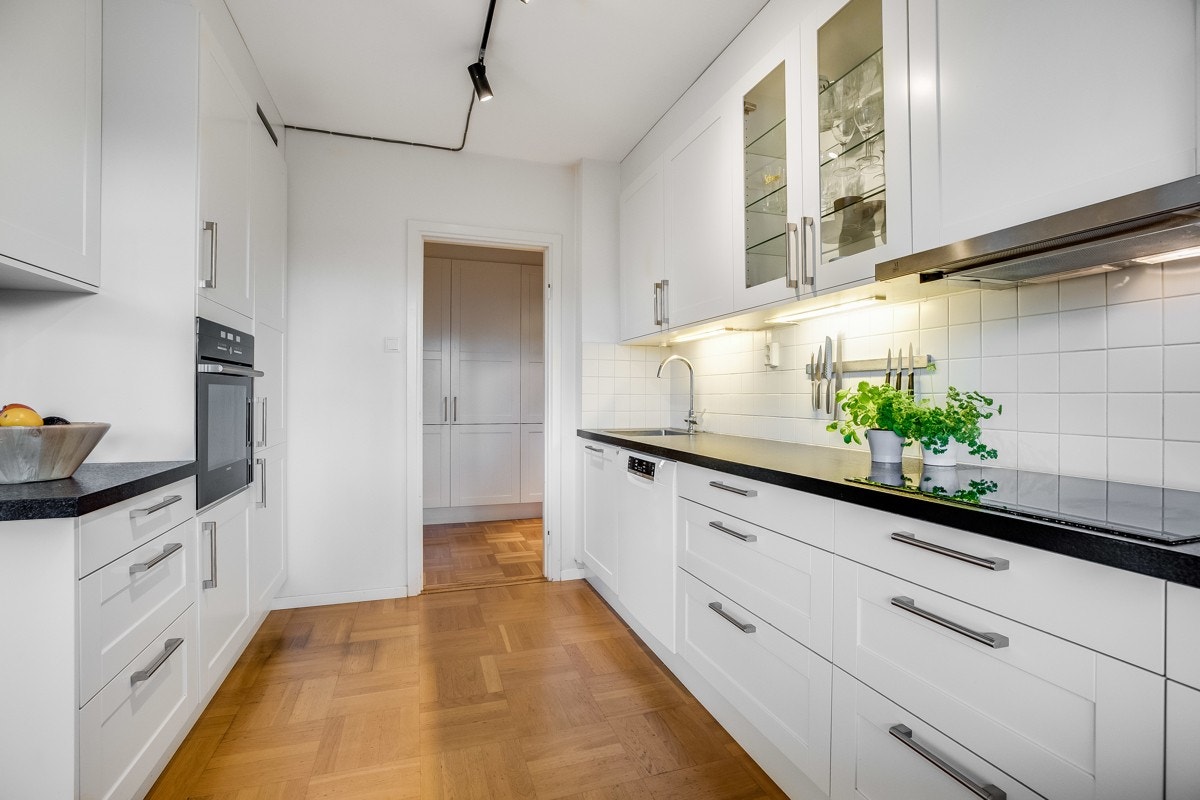 Kjøkkenet er utstyrt med integrerte hvitevarer som oppvaskmaskin, stekeovn, kombinert kjøl/ frys og induksjonskokeplater Galleribilde