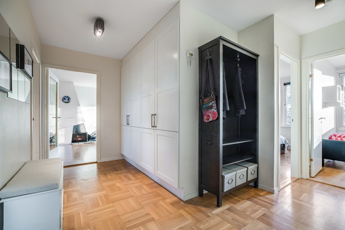 Stor entré/ gang parkett på gulv, samt plassbygde garderobeskap med hvitmalte fronter. Her er det plass til kommode og annnet entrémøblement Galleribilde