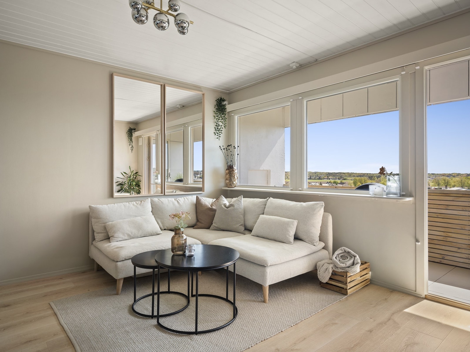 Stuens vindusrekke slipper inn både solstråler og mye naturlig lys. Alle leilighetens vinduer ble skiftet ut i 2015. Galleribilde