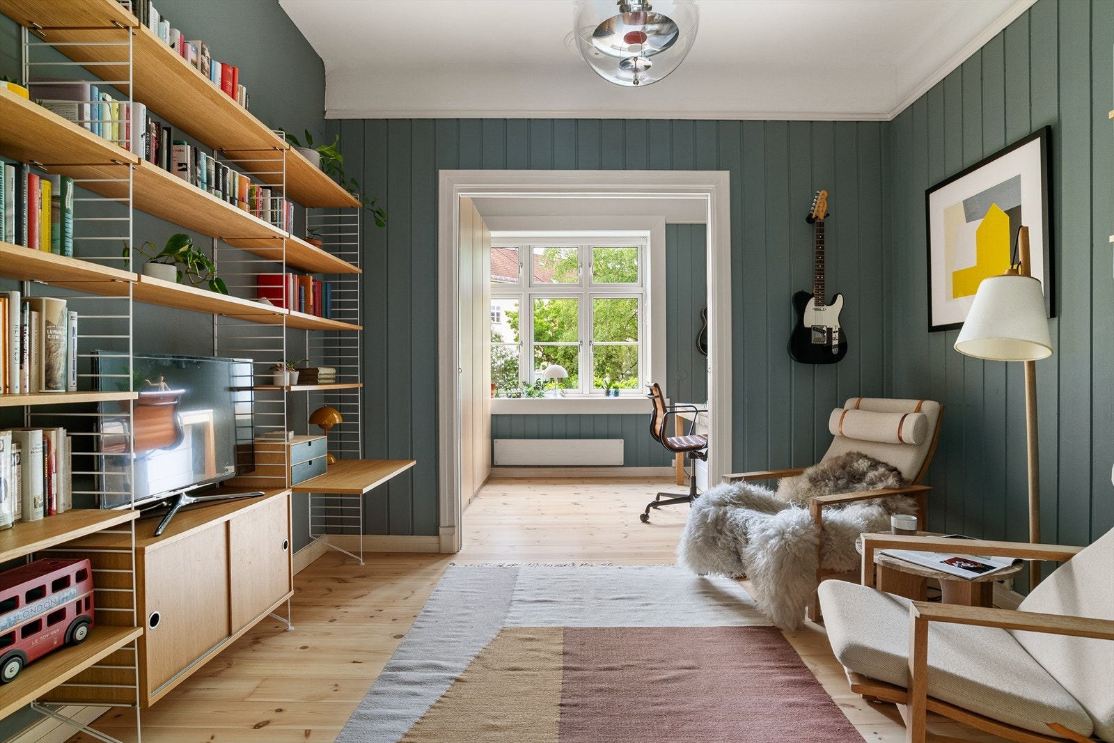 I forlengelse av spisestuen finner du denne koselige plassen som er innredet som tv-rom/ bibliotek. Galleribilde