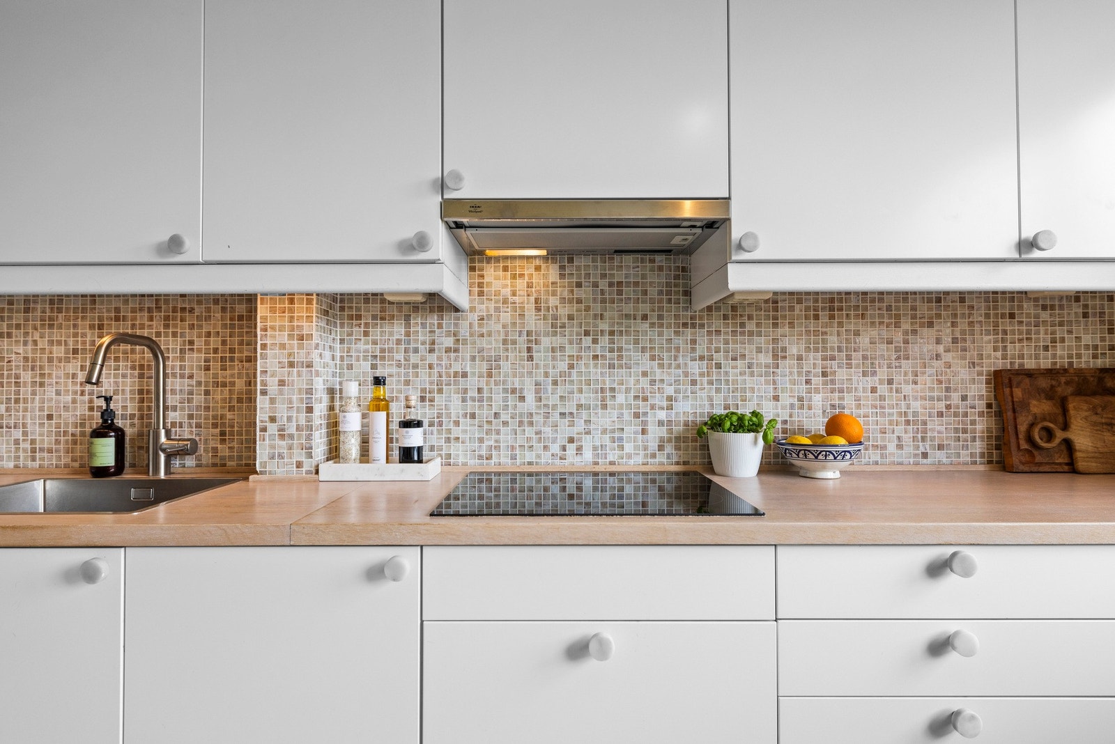 - Pent kjøkken med glatte fronter og benkeplate med finert overflate og kjerne med spon - Galleribilde