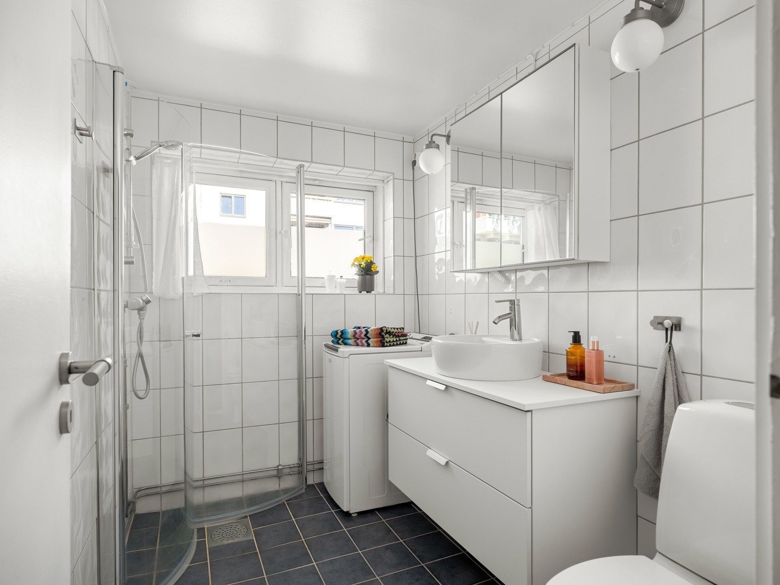 Badet er innredet med dusjhjørne med innfellbare dører, toalett og servant med skuffeinnredning. Her får du også plass- og opplegg for vaskemaskin. Galleribilde