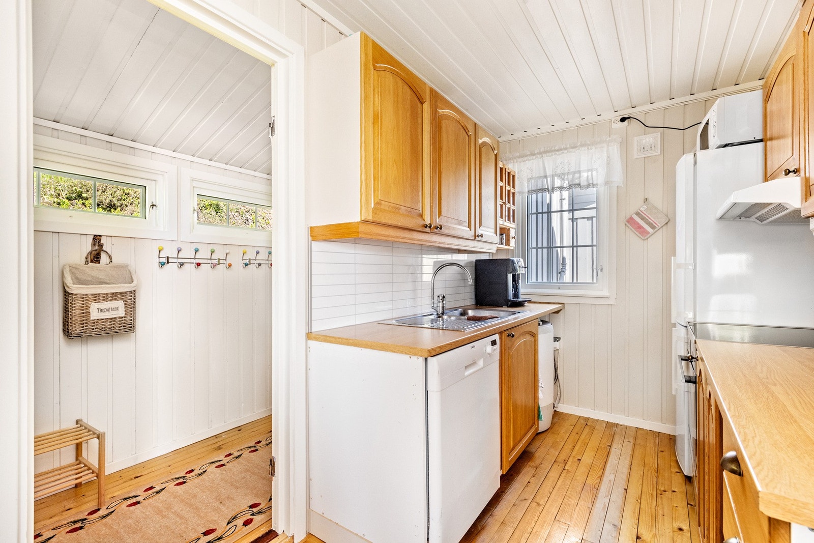 Kjøkken med oppvaskmaskin, komfyr og kjøleskap. Galleribilde