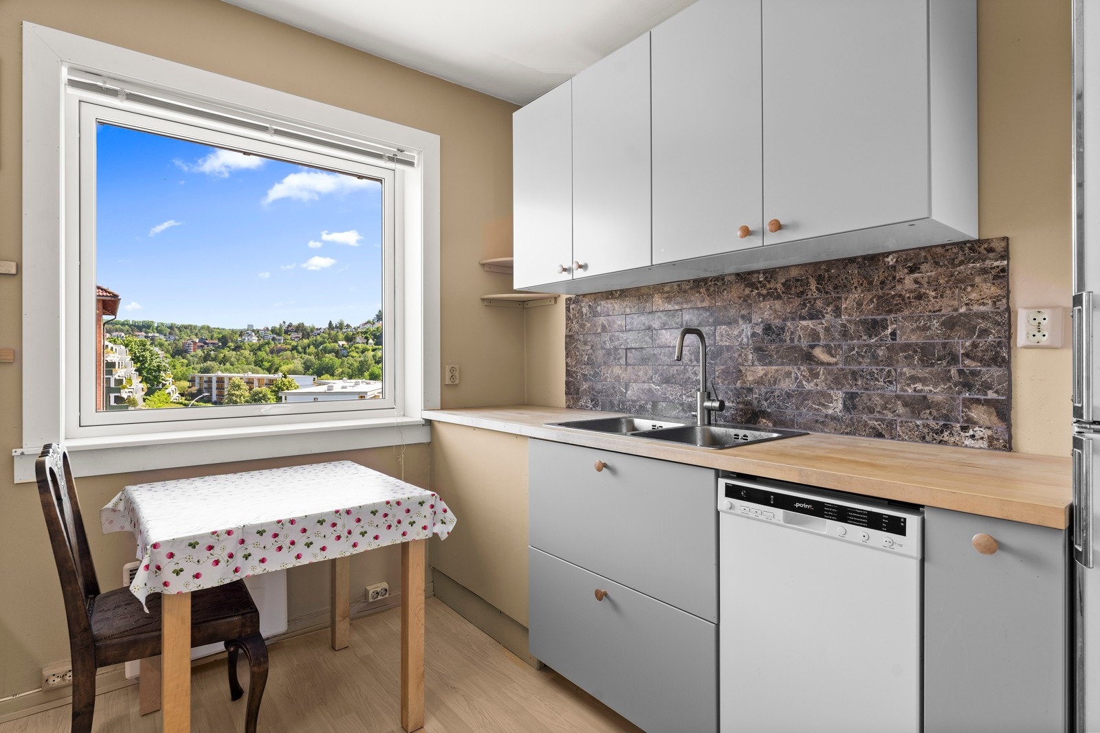 Her er det plass til spisebord ved vinduet, som gir naturlig lys til frokosten. Hvitevarene er frittstående, og ventilasjonen skjer via naturlig avtrekk. Galleribilde