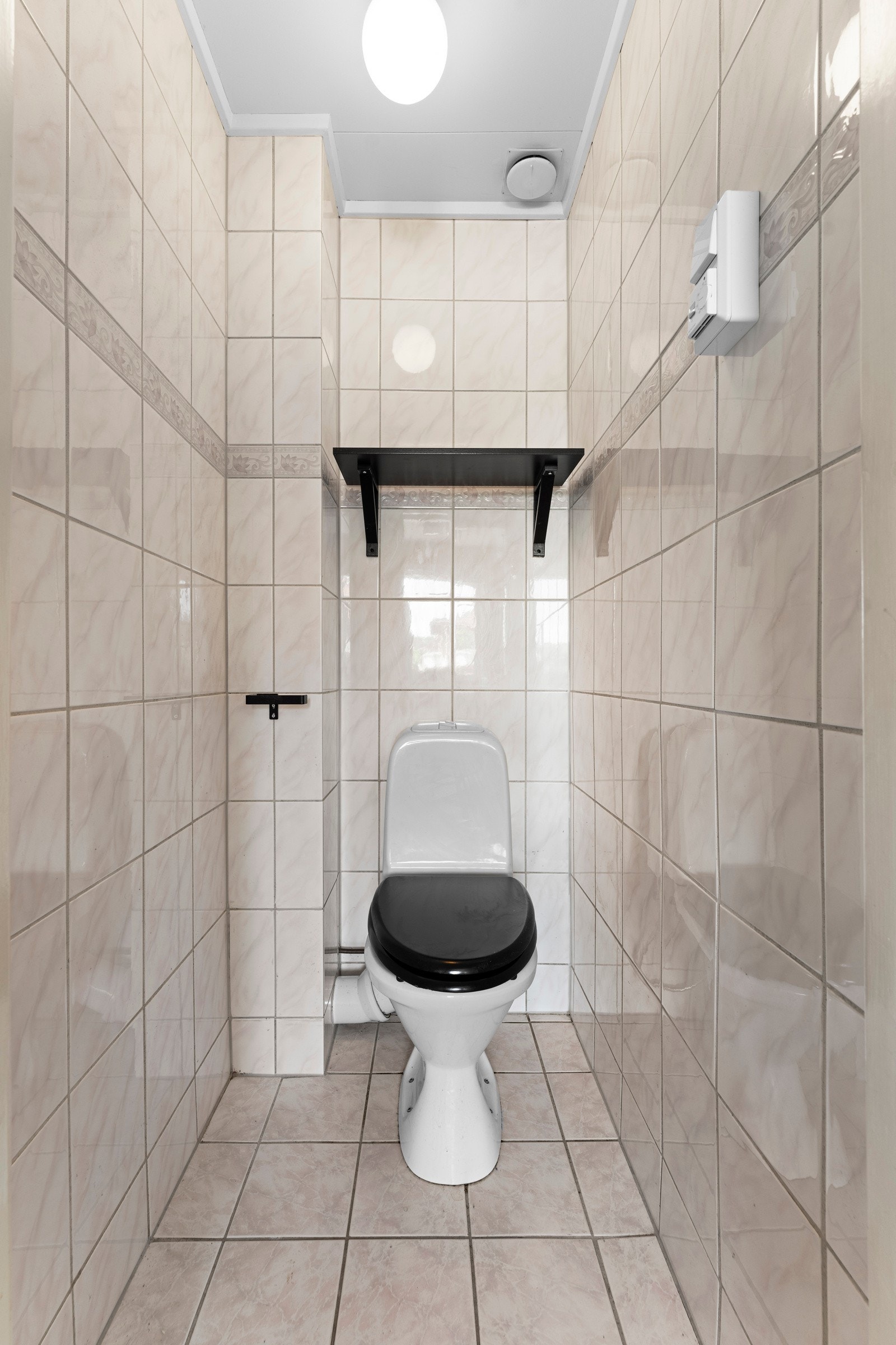 Toalettrommet, også fra ca. 1998, har flislagte gulv med varmekabler og er innredet med gulvstående toalett - en praktisk løsning for familier eller delte boformer. Galleribilde