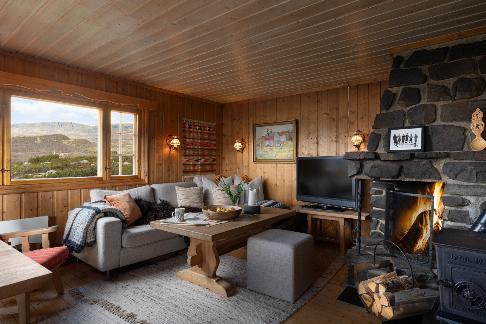 Varm og koselig stue med peis hvor man kan nyte kvelden etter en lang dag utendørs Galleribilde