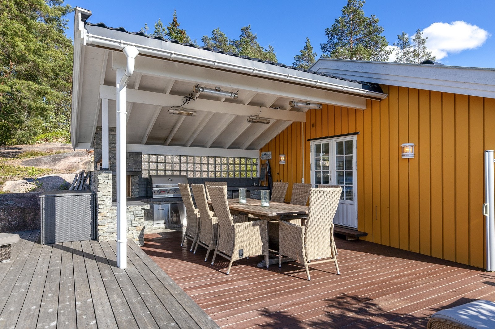 Overbygd del utenfor stuen med spiseplass og godt utstyrt kjøkken. Galleribilde
