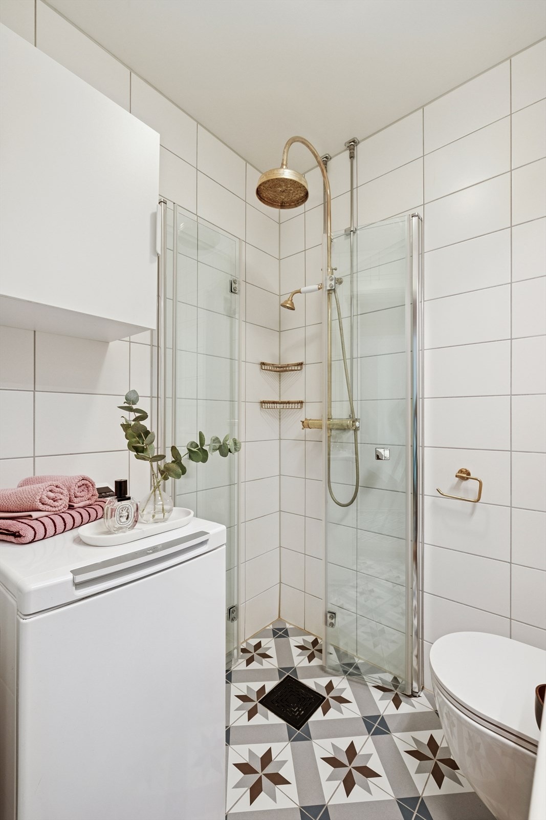 Badet er utstyrt med regnfallsdusj, vegghengt toalett og opplegg for vaskemaskin Galleribilde