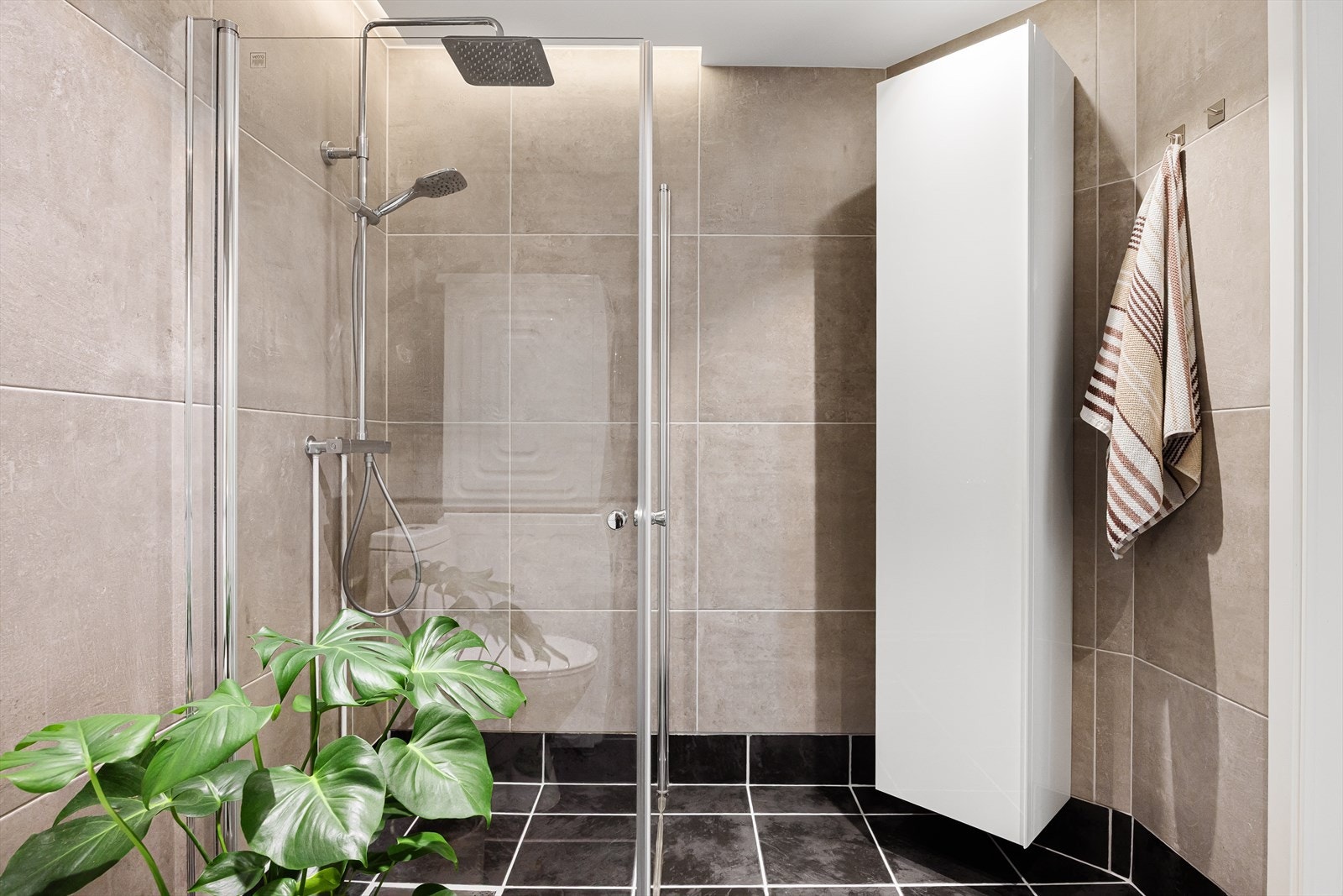 Dusjhjørne med rette svingdører, regnfallsdusj, sluk og termostatstyrt blandebatteri. Galleribilde