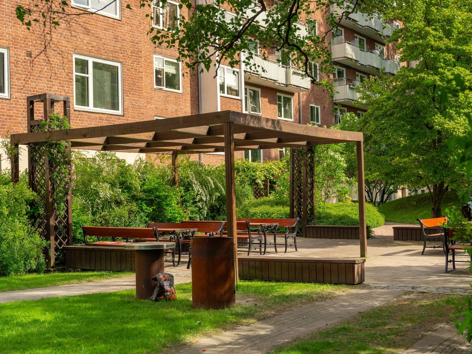 Pergola og flere sittegrupper rundt på aksjelagets eiendom. Galleribilde