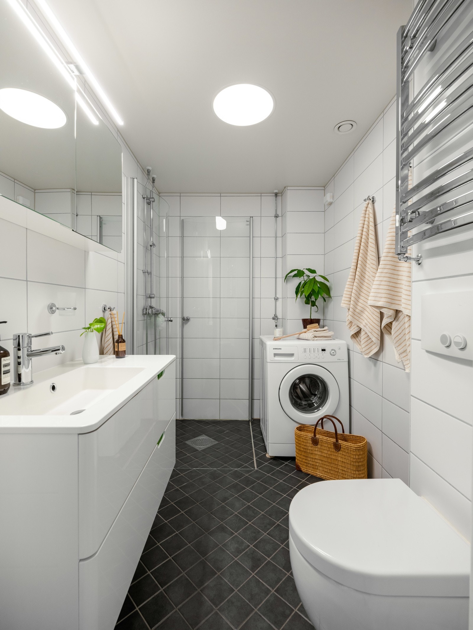 Pent flislagt bad med vannbåren gulvvarme. Det er opplegg for vaskemaskin. Galleribilde