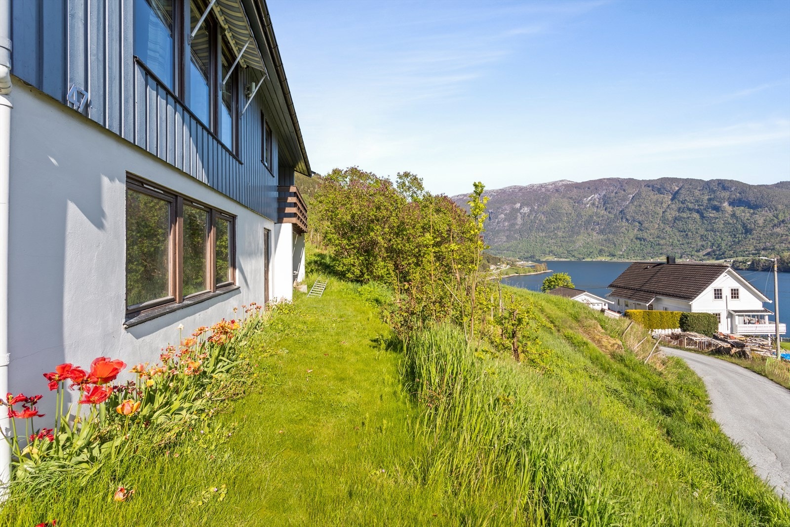 Det er opparbeida hage med plen og fine blomster i bed. Galleribilde