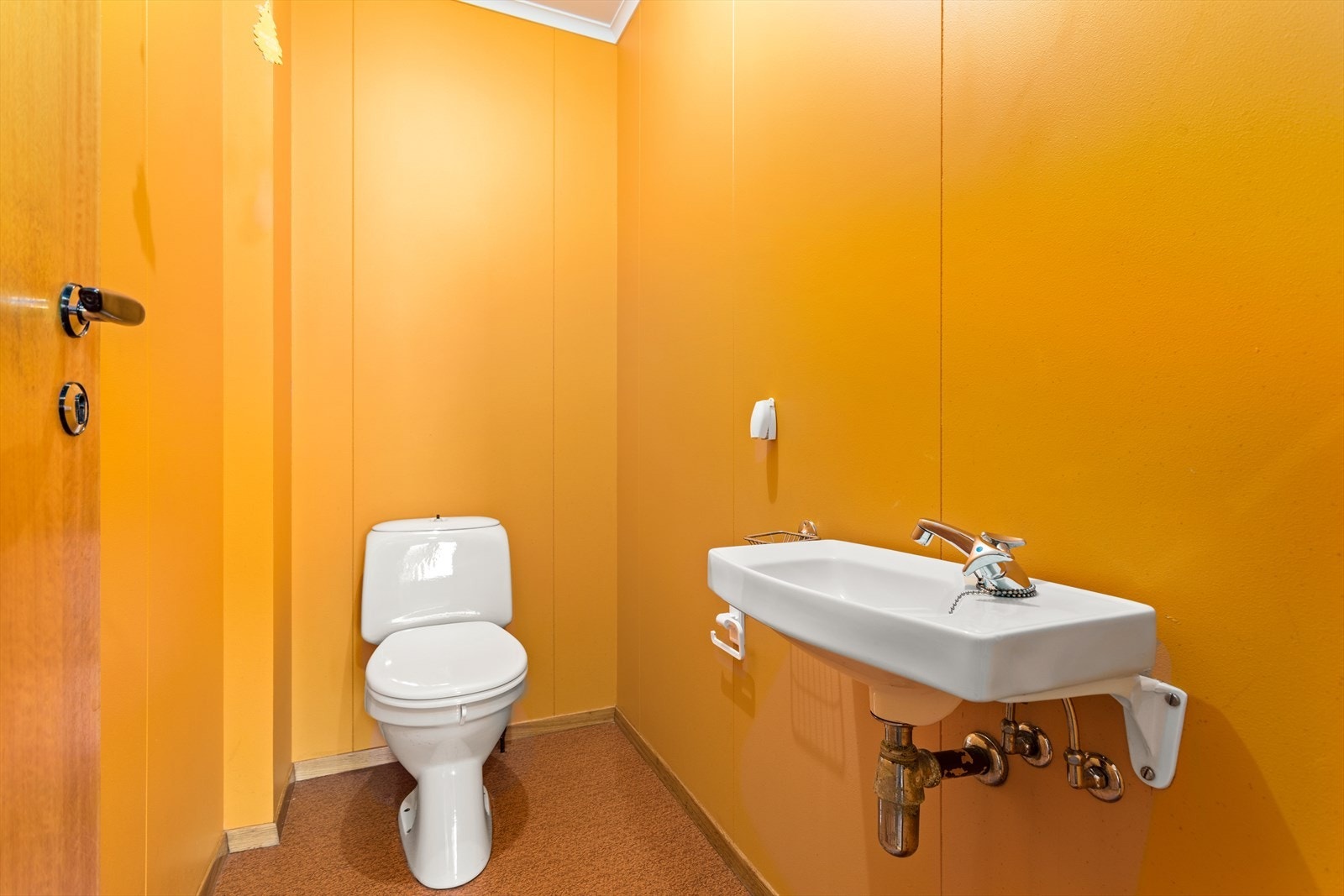 Toalettet inneheld enkel vegghengt servant og klosett. Galleribilde