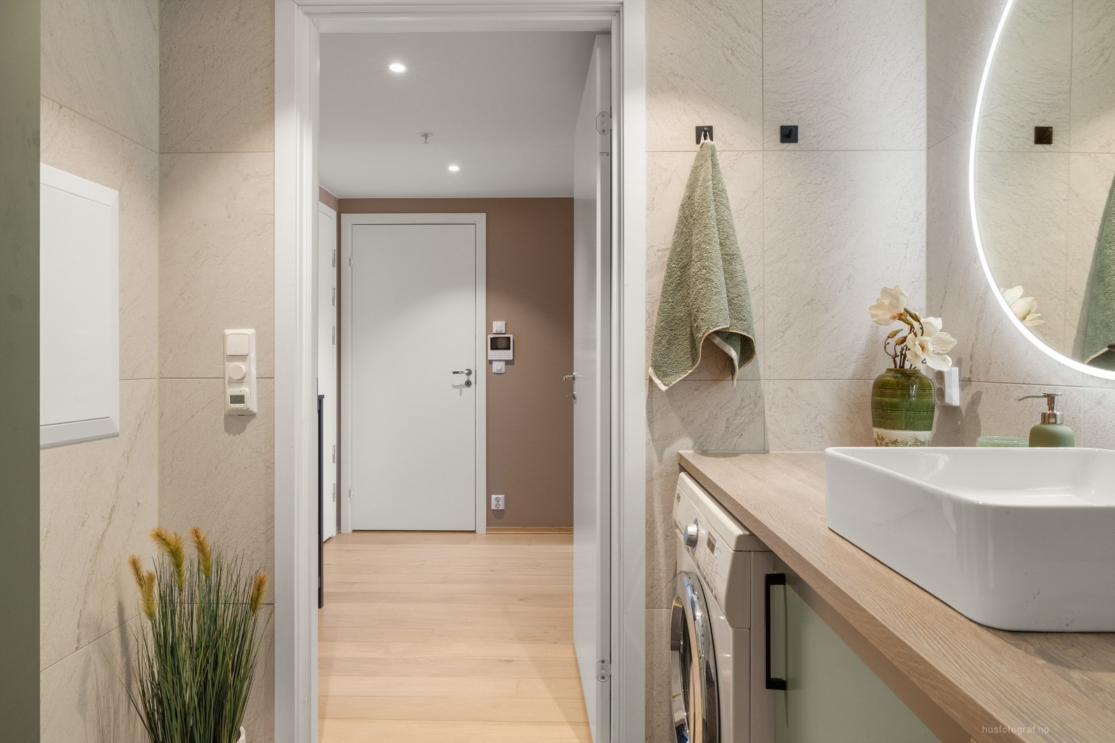 Badet har en plassbygd servantinnredning med ovenpåliggende servant, nisje for vaskemaskin og underskap for lagring Galleribilde