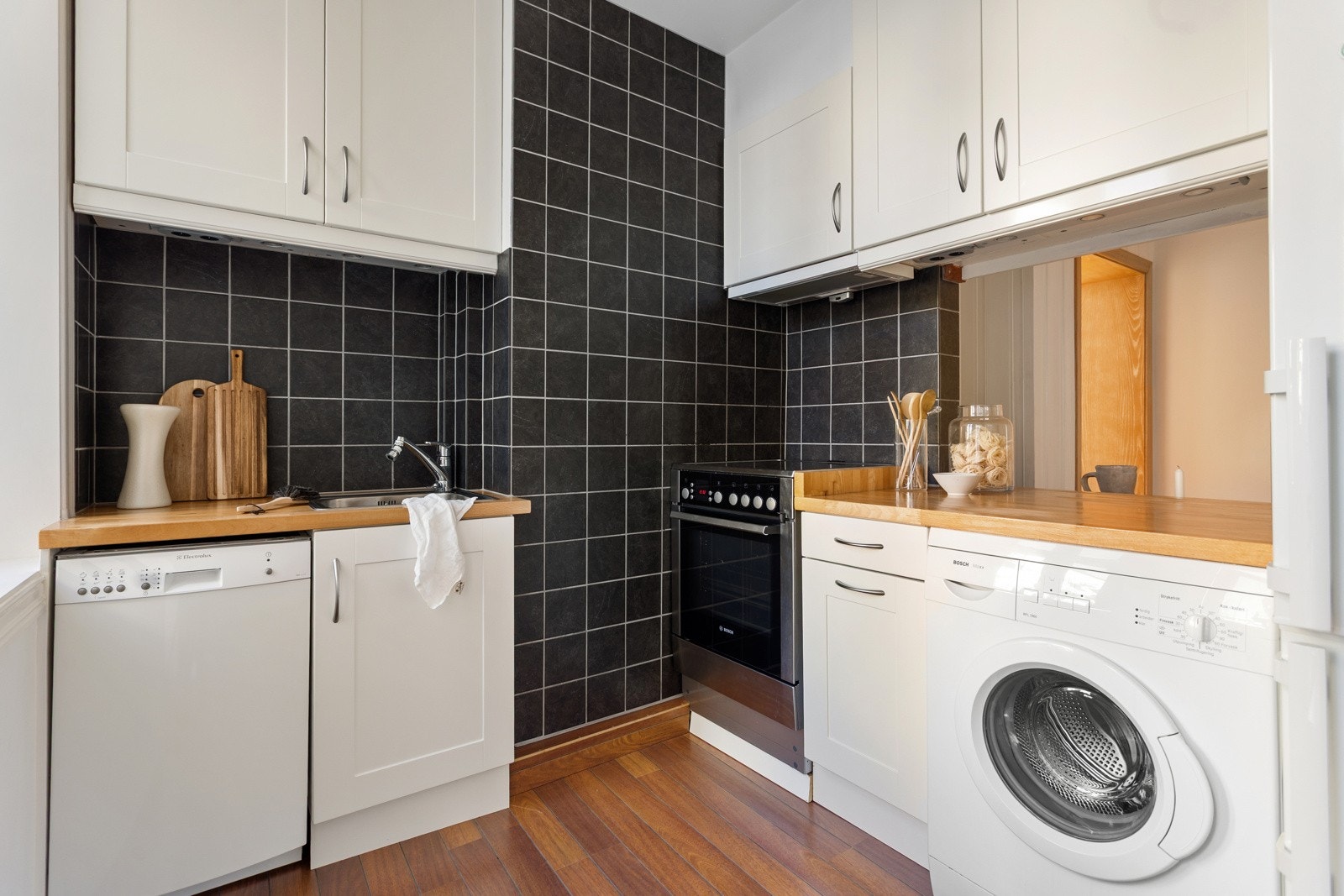 Pent Ikea kjøkken med profilerte fronter og benkeplate i tre. Galleribilde