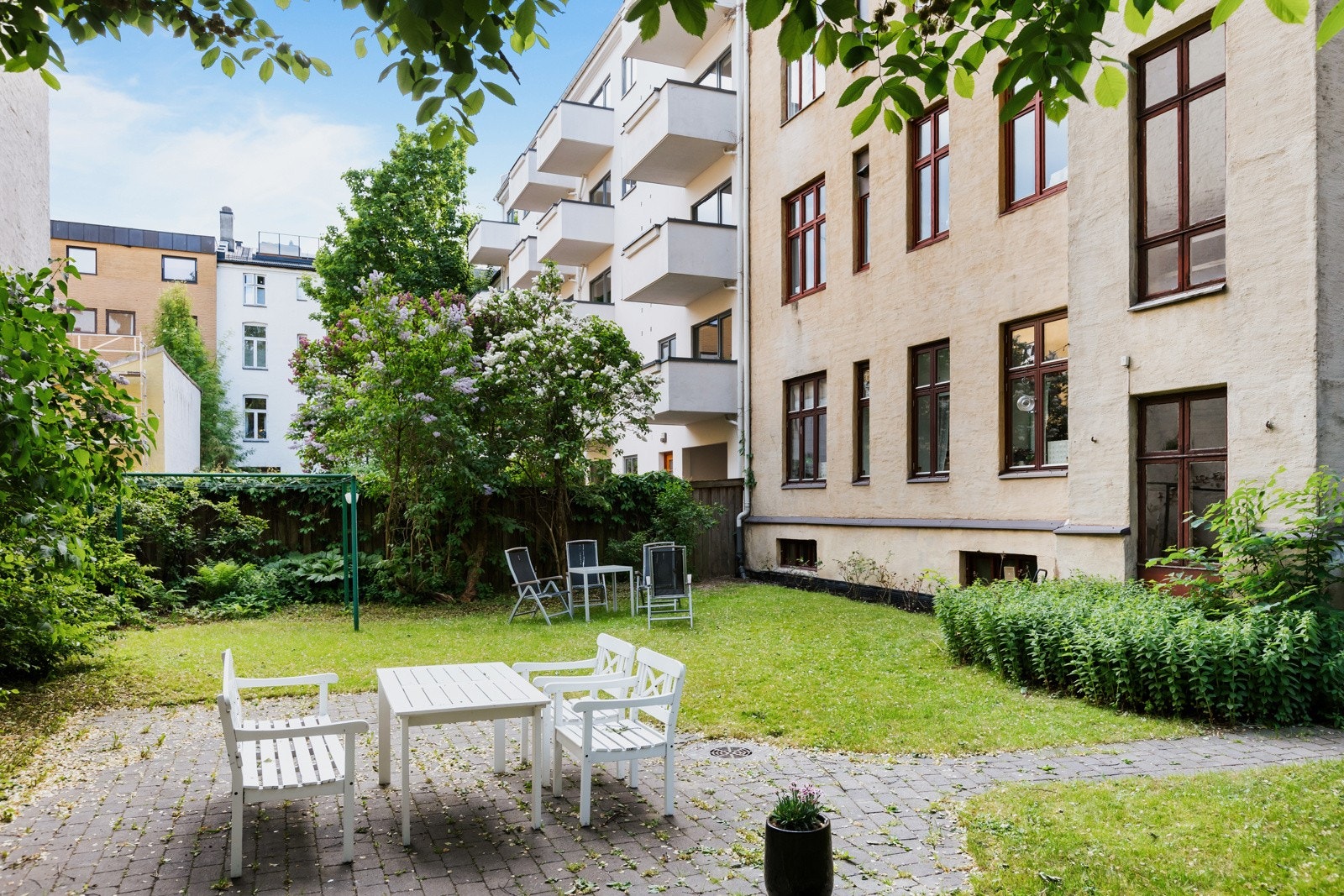 Sameiet har en bakgård med plen, sykkelparkering og utemøbler på sommeren. Galleribilde