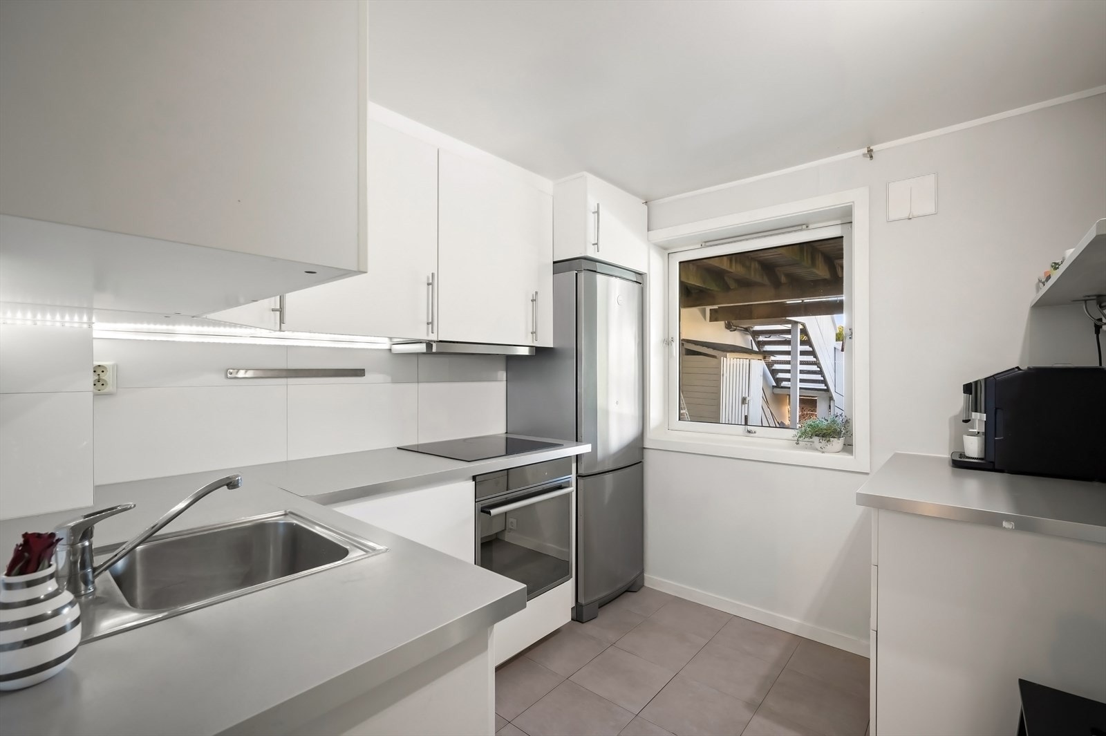 Kjøkken med integrert oppvaskmaskin, komfyr og platetopp. Nisje for kjøleskap. Kjøkkenventilator med avtrekk ut. Galleribilde